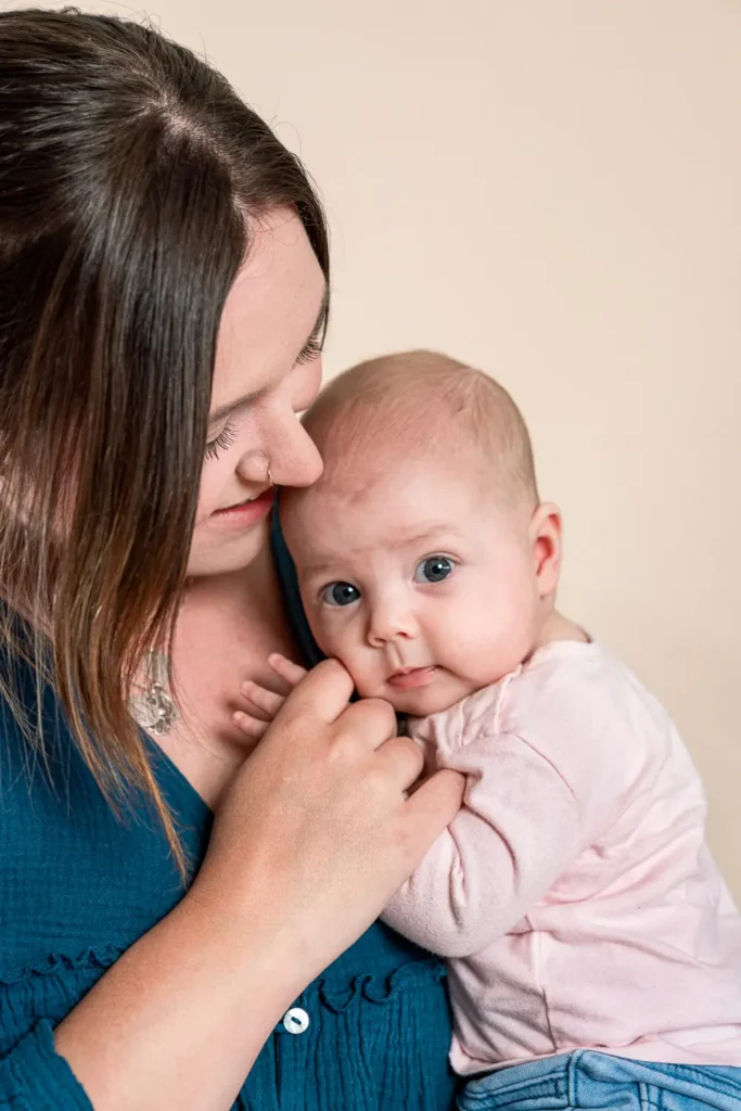 Newborn baby held by mother in a close-up portrait for annual report photography