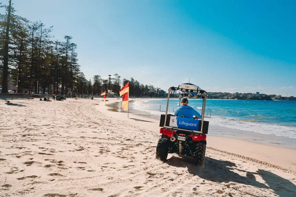 Lifeguard scanning ocean from beach ATV Manly, Northern Beaches