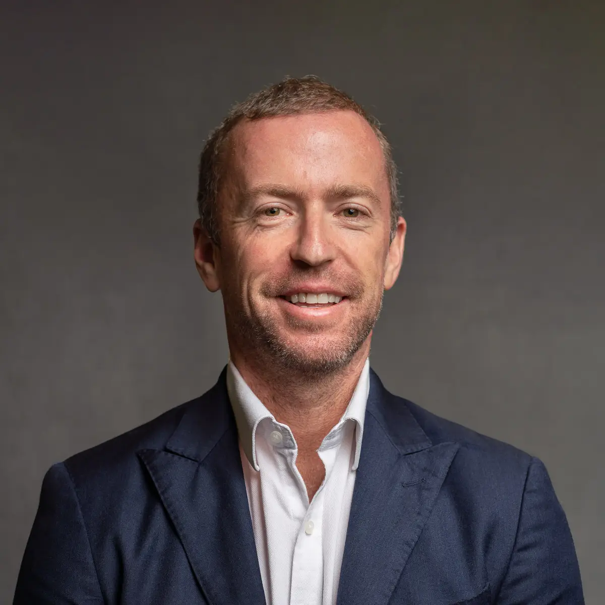studio headshot of a man in an office attire on the black background