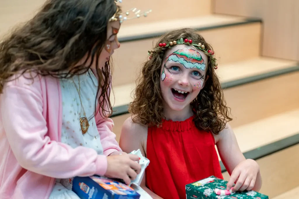 Child opening a gift at a family Christmas function in Sydney