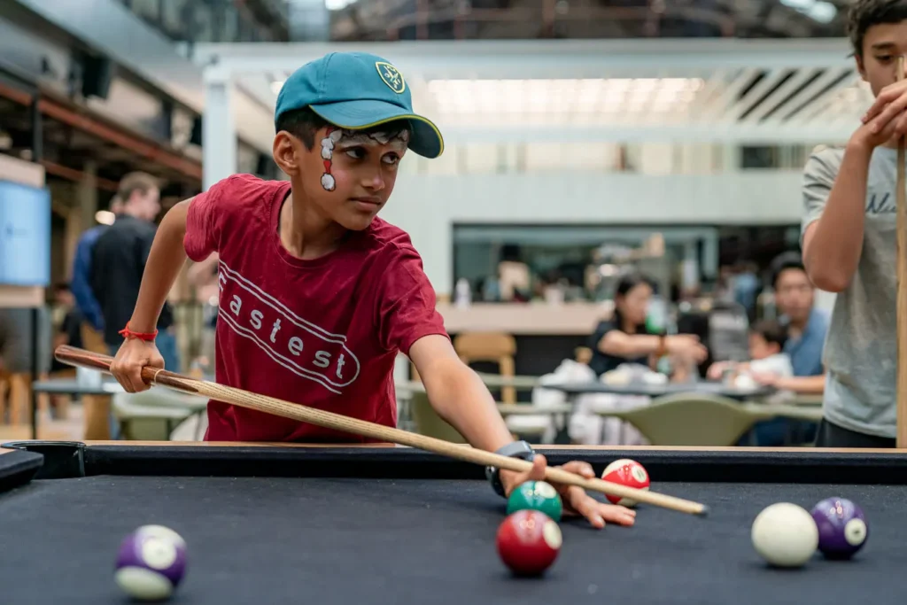 Child playing pool during a family Christmas event in Sydney