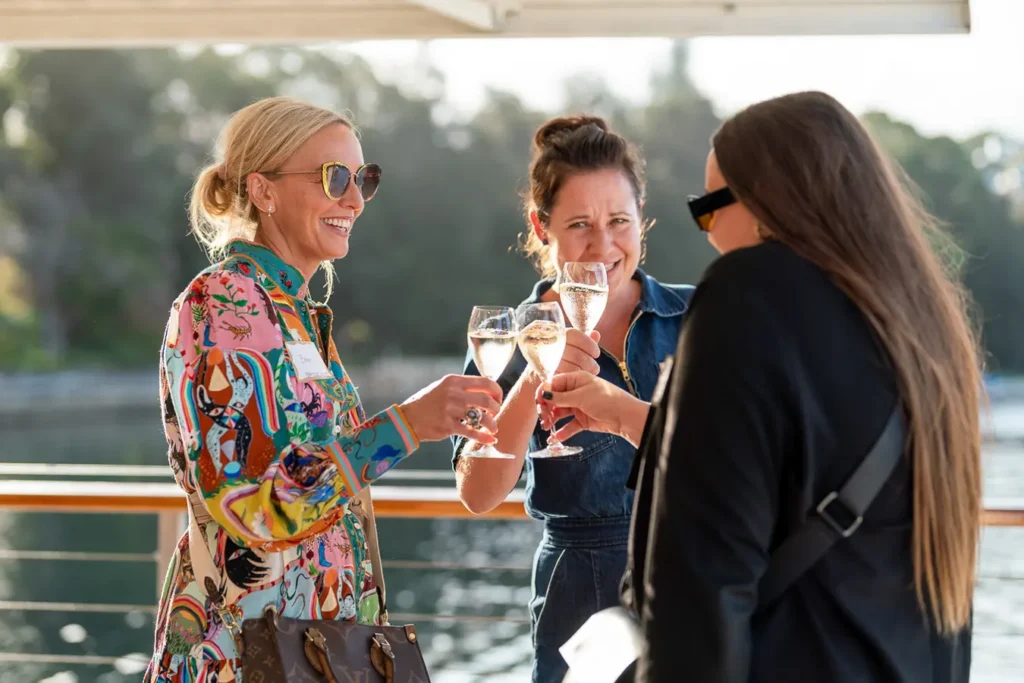 Guests toasting drinks at a Sydney Christmas party function by the water
