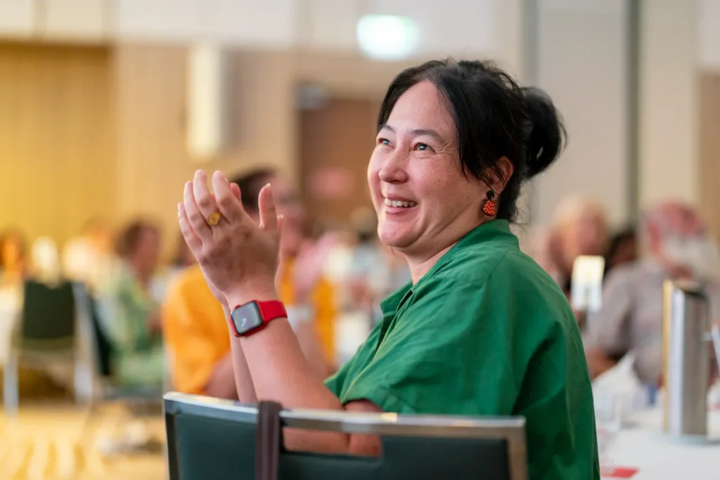 Guest smiling and applauding during the conference at PARKROYAL Parramatta