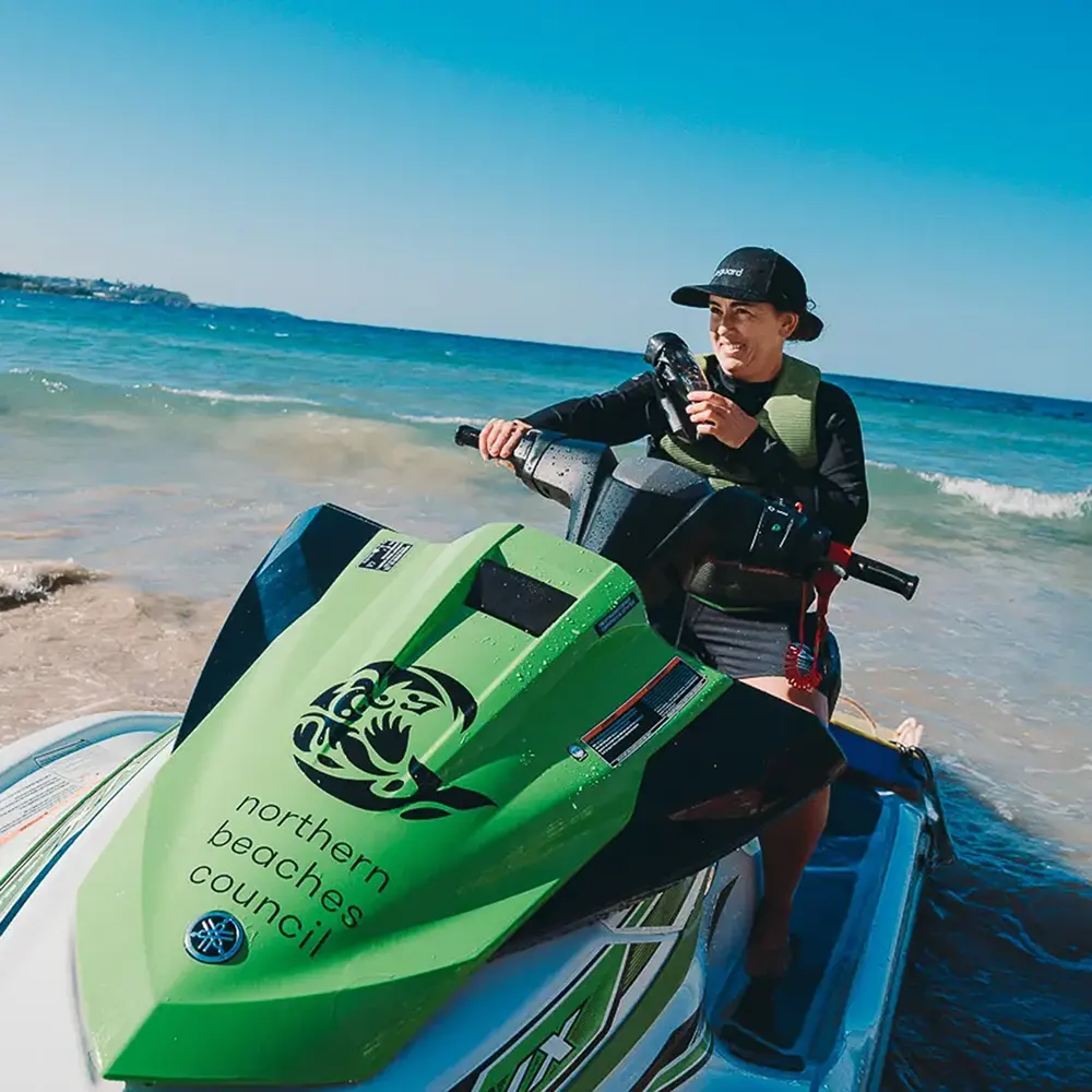 northern beaches lifeguard demonstrates skills of using branded jet ski at manly beach