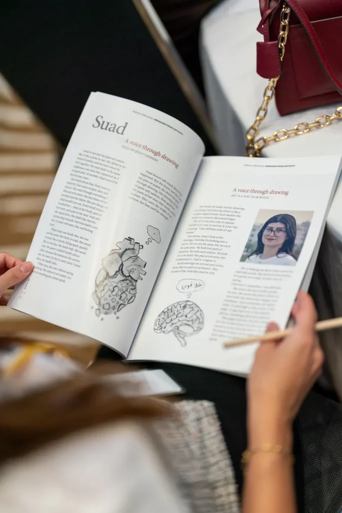 Open pages of Messages from Captivity showing artwork and writing from the book