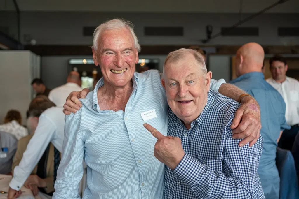 Two guests smiling together at the Michael Morgan OAM lunch