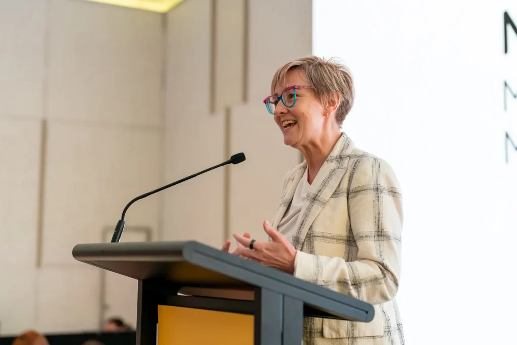 Minister Jodie Harrison speaking at the podium during the conference