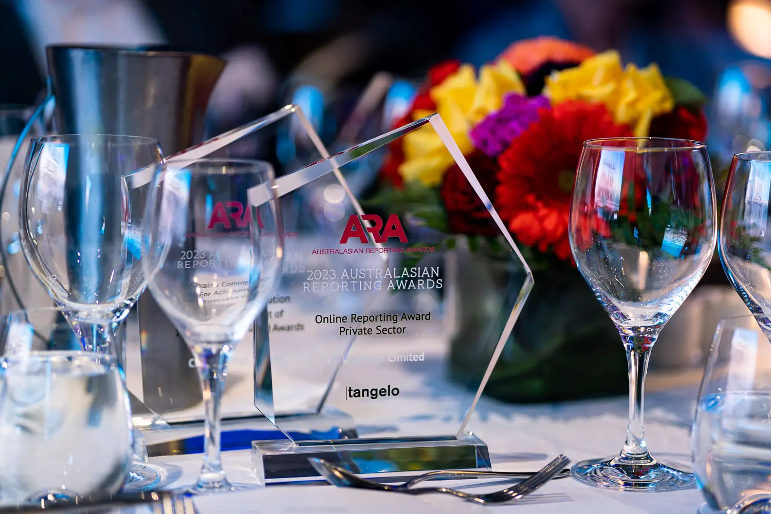 Australasian Reporting Awards trophies displayed on a black-tie dinner table at the 2023 ARA gala