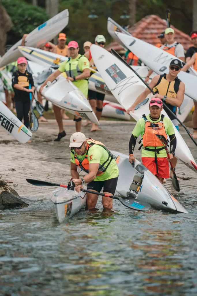 Competitors carrying surf skis at the Sydney Harbour fundraising event
