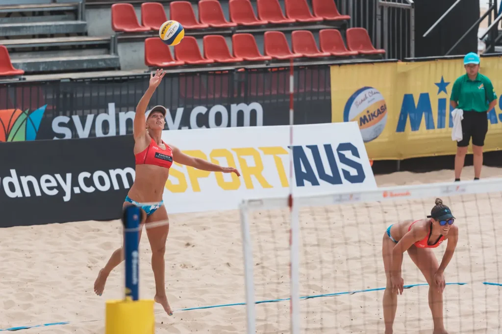 Australian beach volleyball player serving during an international match at Manly Beach