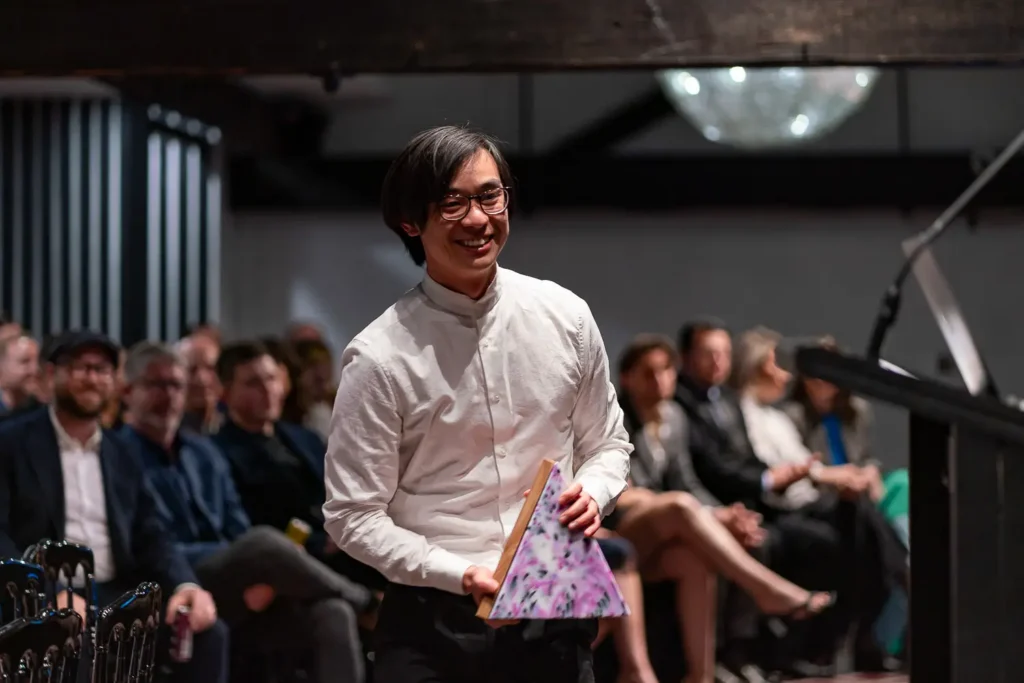 Award winner walking to stage holding Australian Web Awards trophy