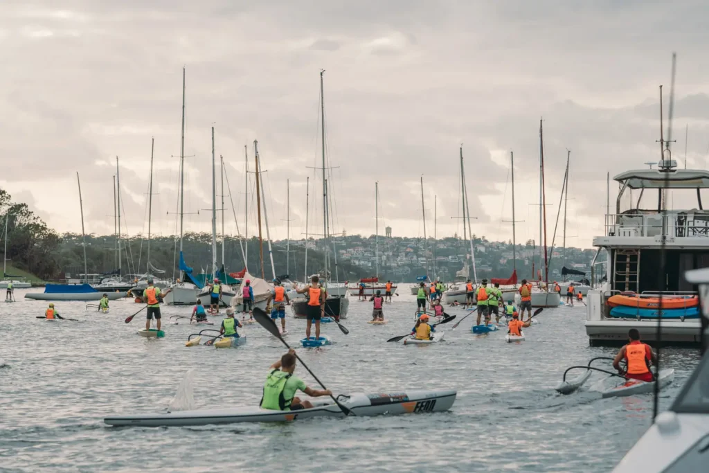 Competitors paddling through Sydney Harbour during the charity race