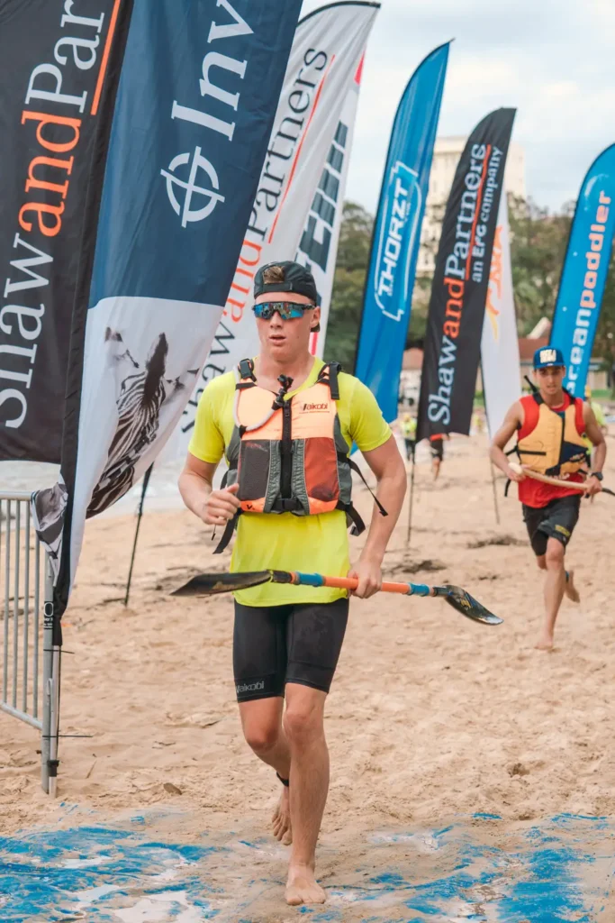 Surfski competitors and spectators gathered along the beach at a Sydney paddling event