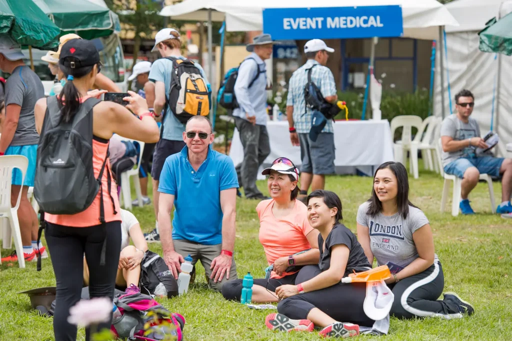 Participants resting beside the walking route during the Bridges Walk in Sydney