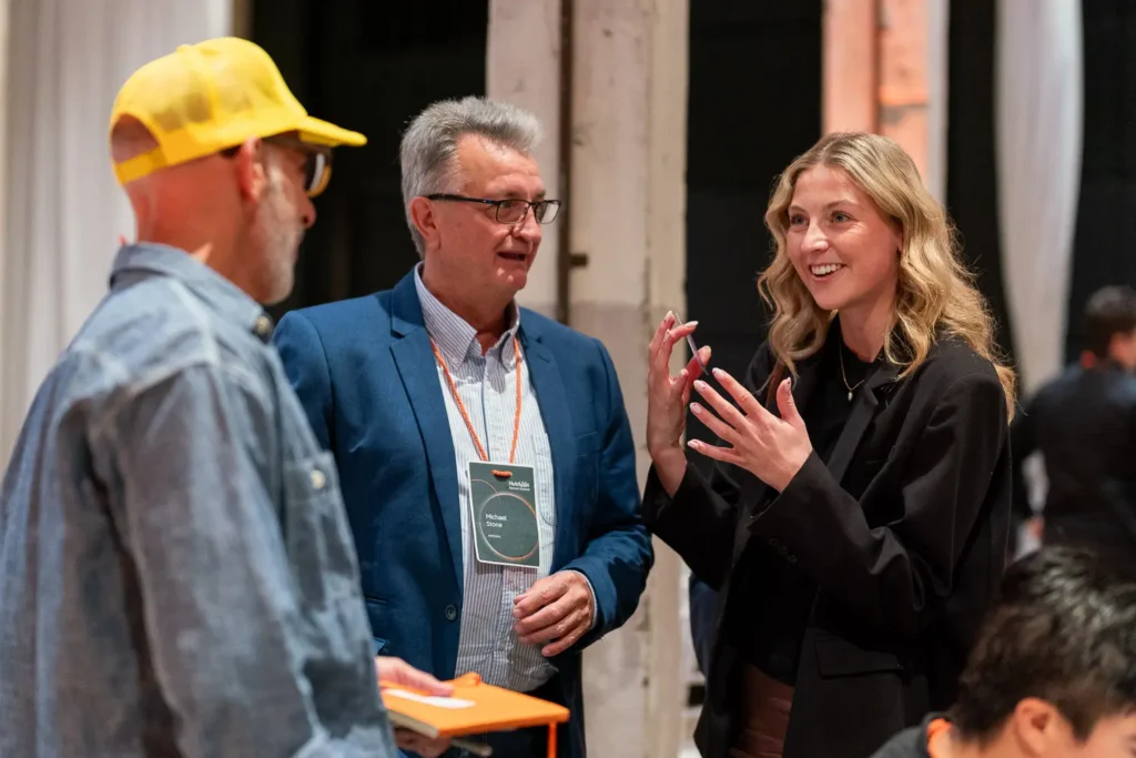 Three attendees engaged in conversation during a HubSpot Partner Summit networking session