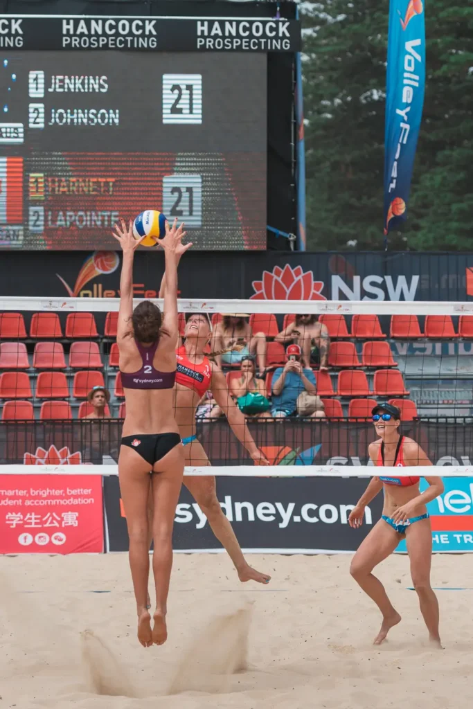 Canadian beach volleyball player jumping for a block during an international match
