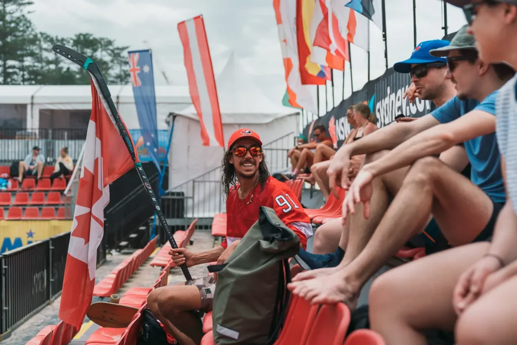 Canadian supporter holding a hockey stick and flag during the beach volleyball event at Manly