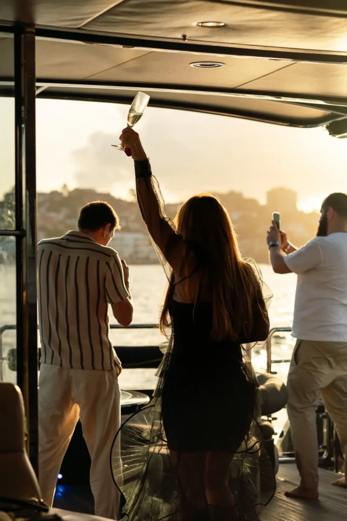 Guests enjoying champagne and sunset views during a yacht celebration