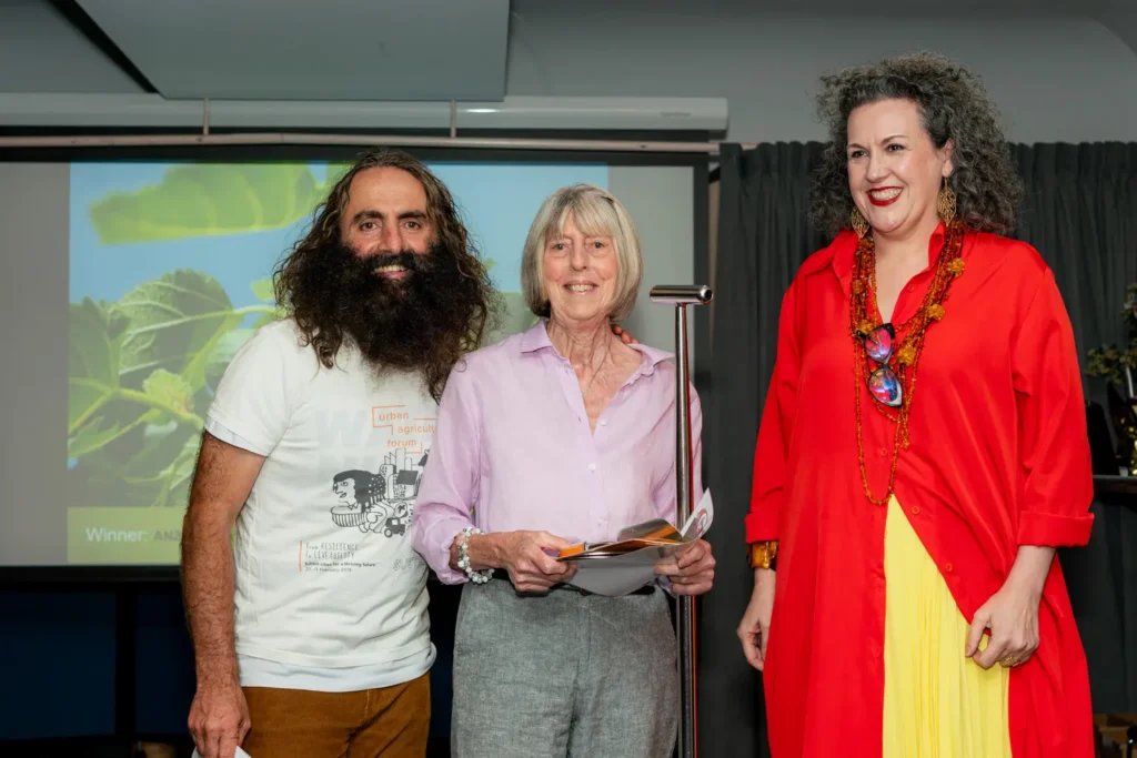 Award recipient posing with organisers at community garden awards event
