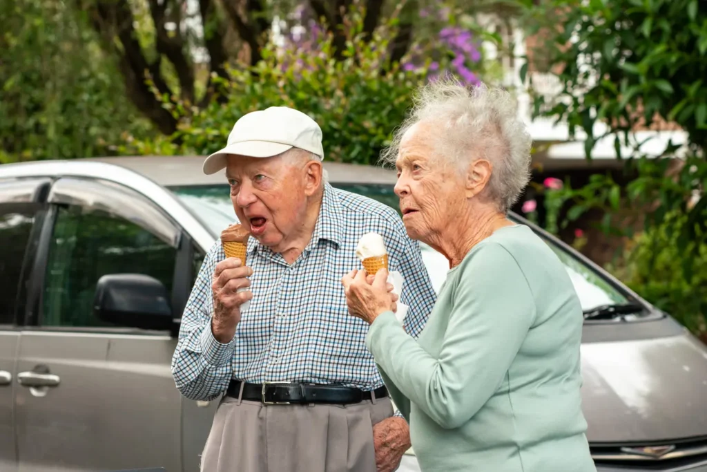 Elderly couple eating ice cream together at a local community street festival
