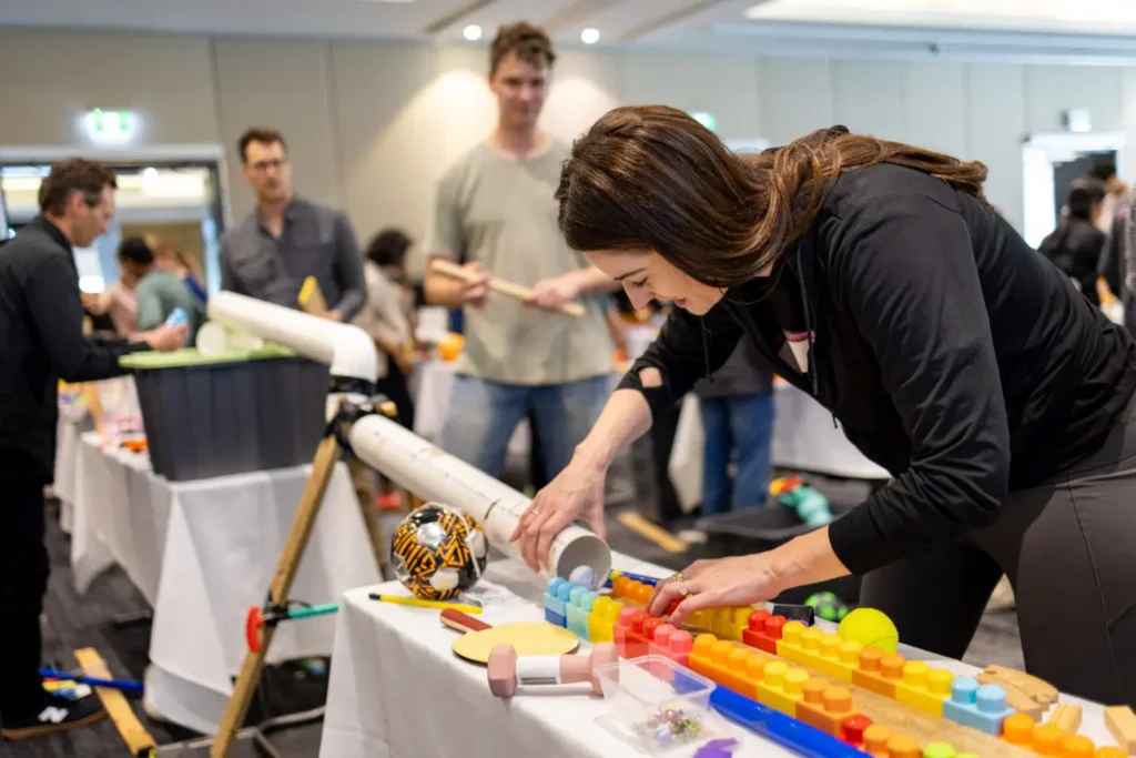 Participants building and testing creative engineering challenges at a team event