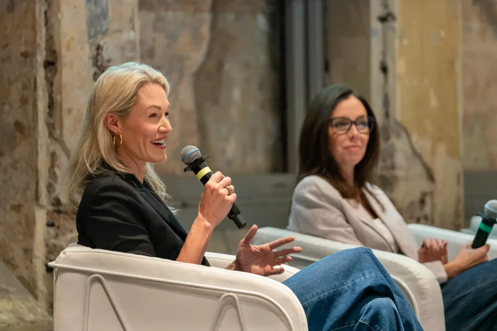 Erika Fisher speaking during a corporate panel discussion at a partner summit conference event