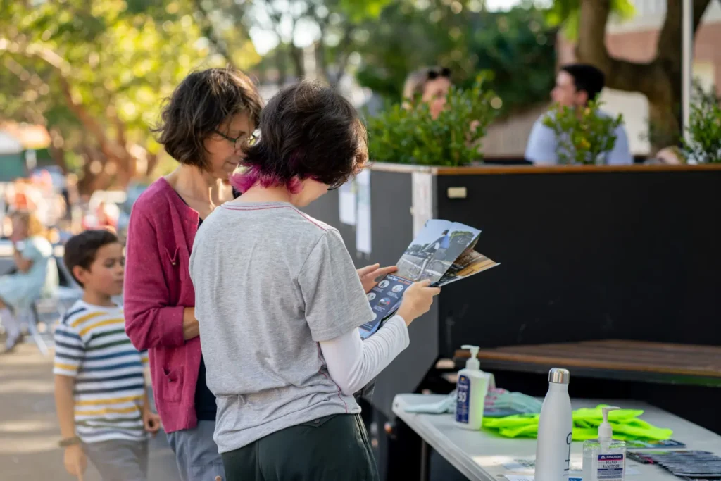 Family reading brochures at an information stall during a local neighbourhood event