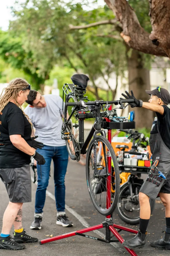 Bike mechanics servicing bicycles during North Sydney Street Play event