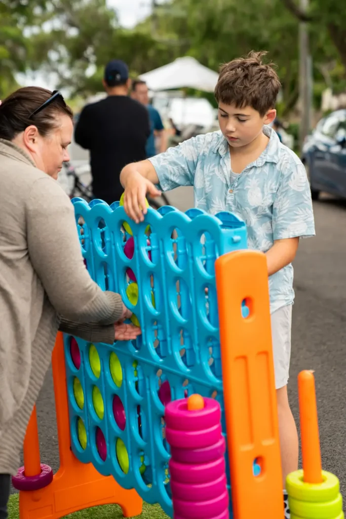 Family playing giant Connect Four game during North Sydney community event
