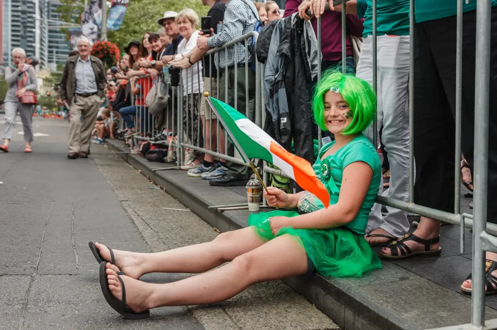 Young girl in green costume holding Irish flag at Sydney street parade
