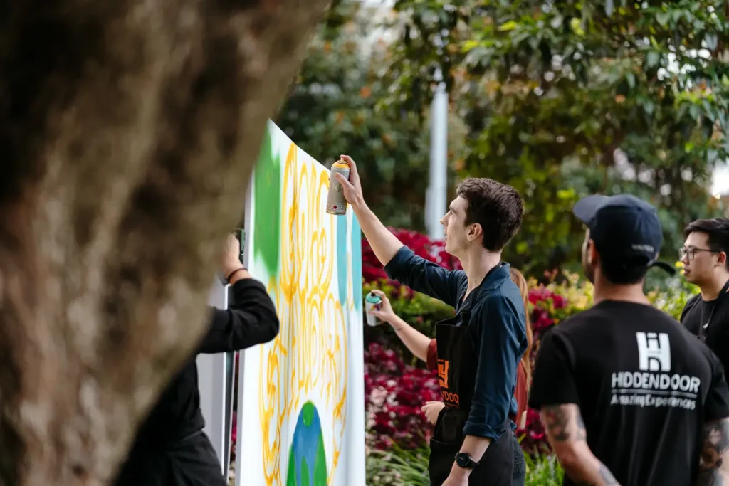 Employees creating collaborative graffiti artwork at a Sydney team building event