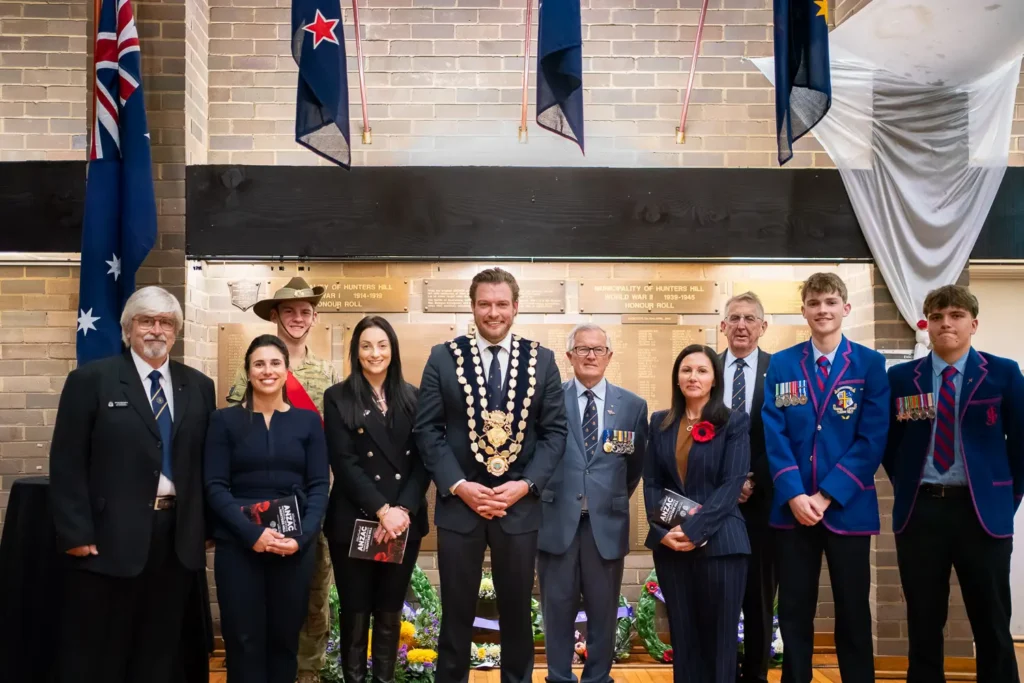 Group portrait of community leaders, veterans, students, and defence representatives at memorial hall