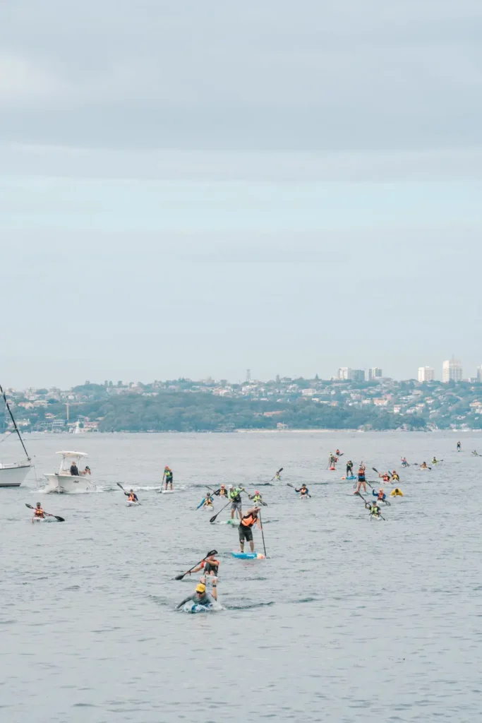 Wide view of paddlers spread across Sydney Harbour during a long-distance ocean race