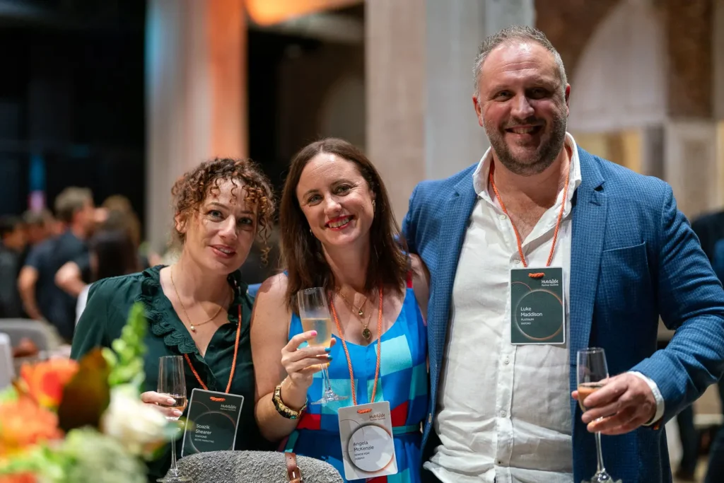 Three attendees posing together with drinks at the HubSpot Partner Summit social event