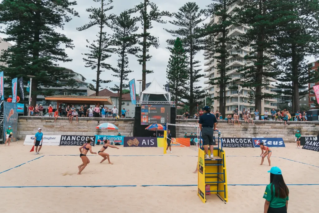 Wide view of international beach volleyball match and crowd at Manly Beach