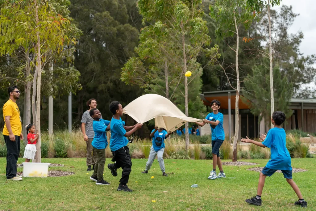 Children playing outdoor team games during a group development activity