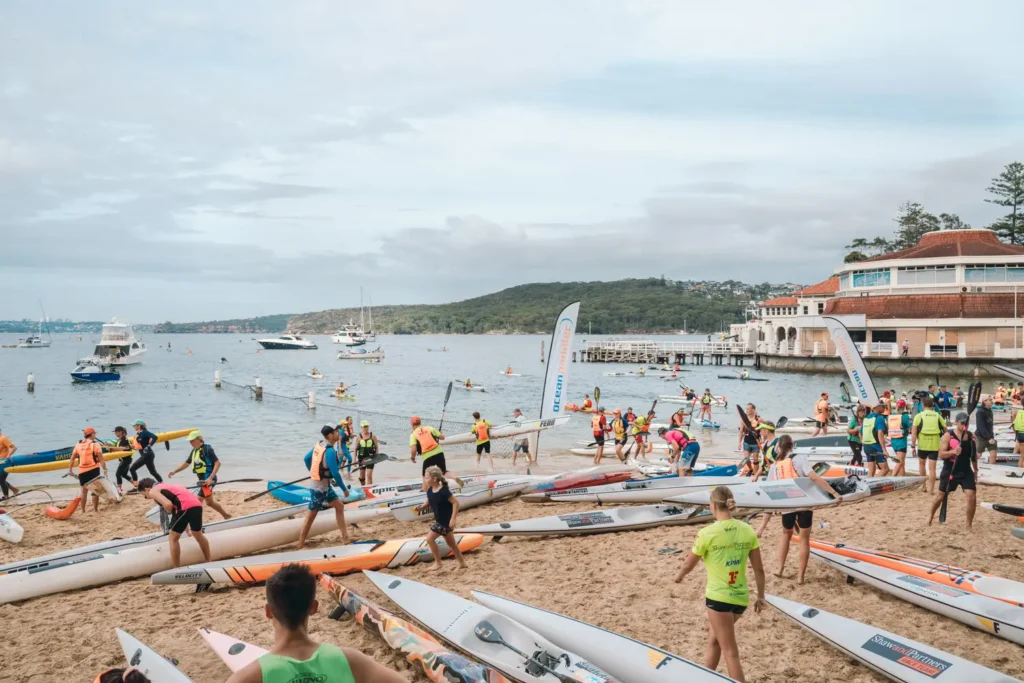 Surfski paddlers arriving at the beach finish area near Manly Wharf
