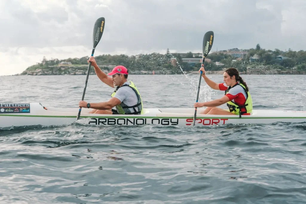 Male and female paddlers competing together in a double surf ski on Sydney Harbour