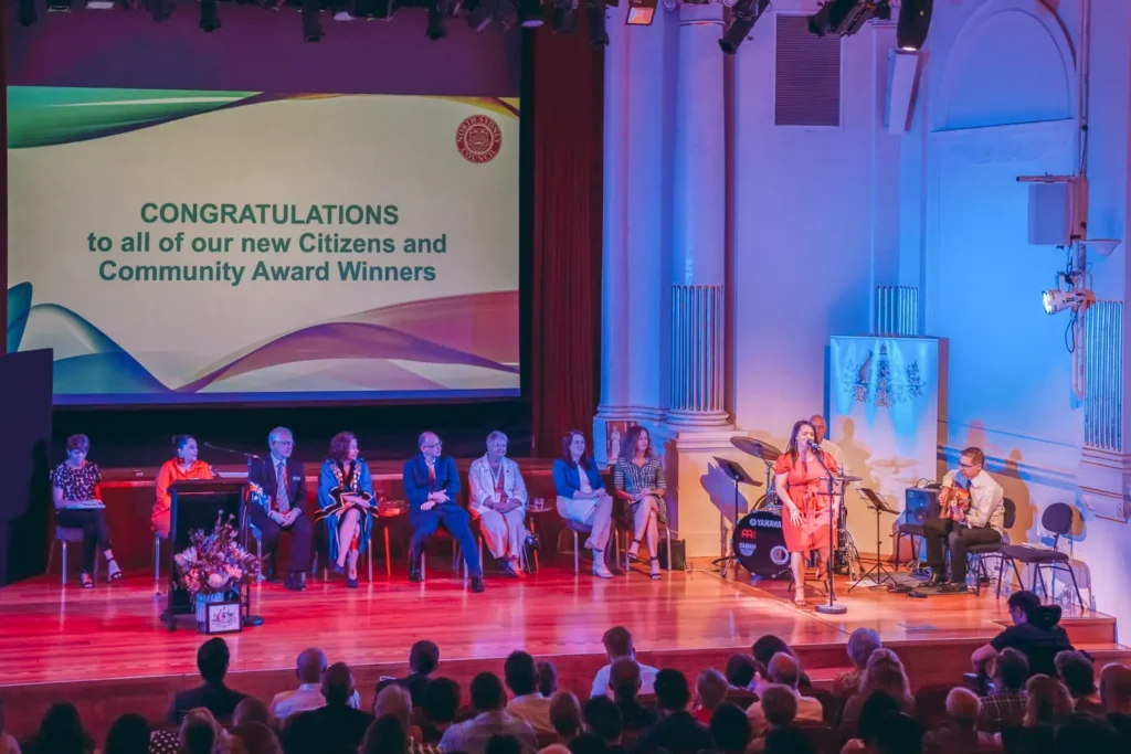 Community awards ceremony stage with speakers and live music performance