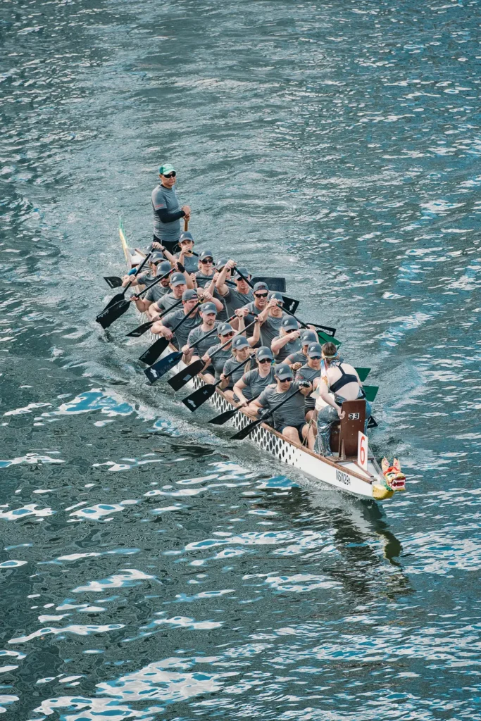 Overhead perspective of synchronized dragon boat paddlers cutting through water
