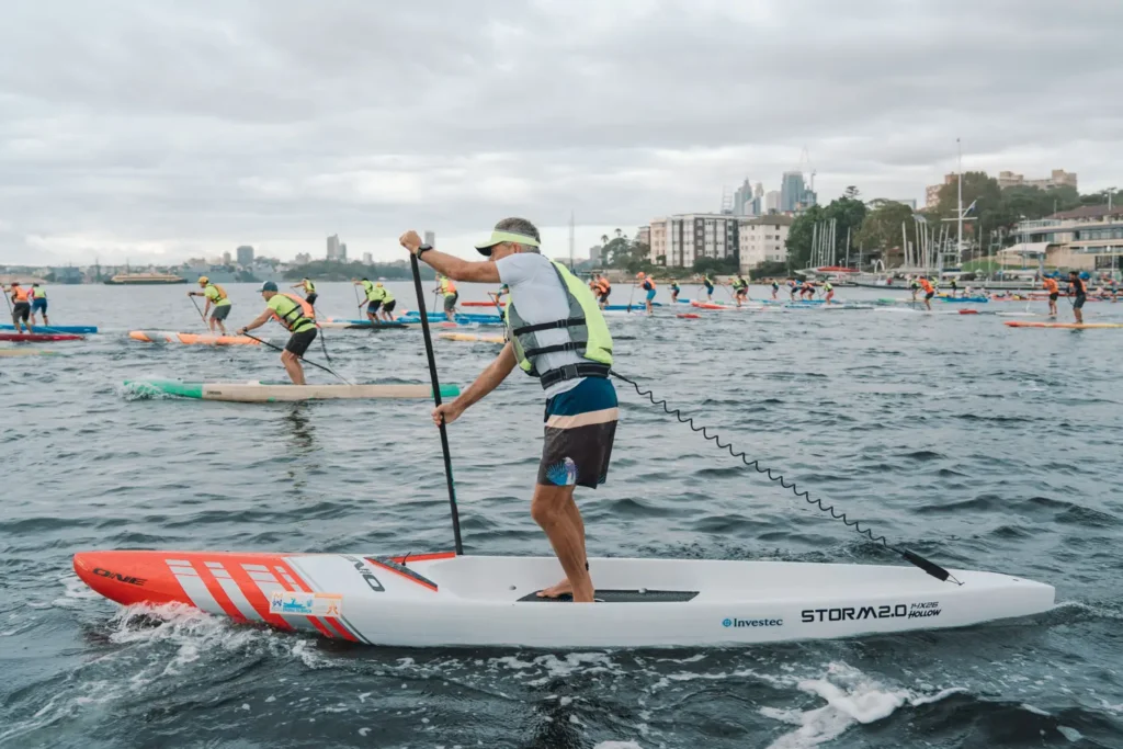 Paddleboard competitors racing across Sydney Harbour during the charity event