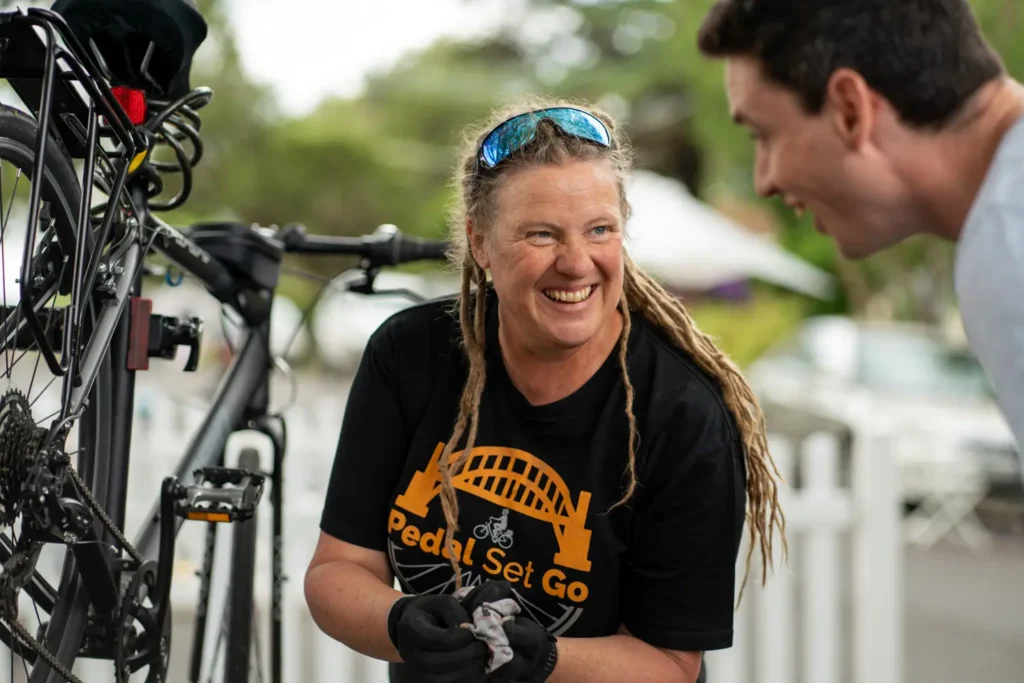 Bicycle mechanic speaking with resident during free bike maintenance event