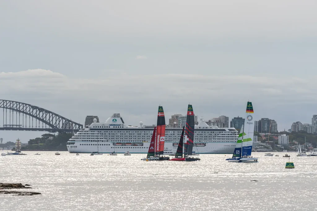 SailGP race fleet on Sydney Harbour with the Harbour Bridge and cruise ship in the background