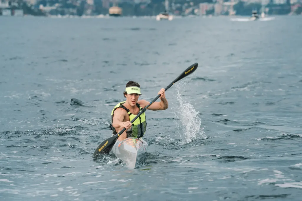 Solo surfski paddler powering through open water during an endurance paddle race