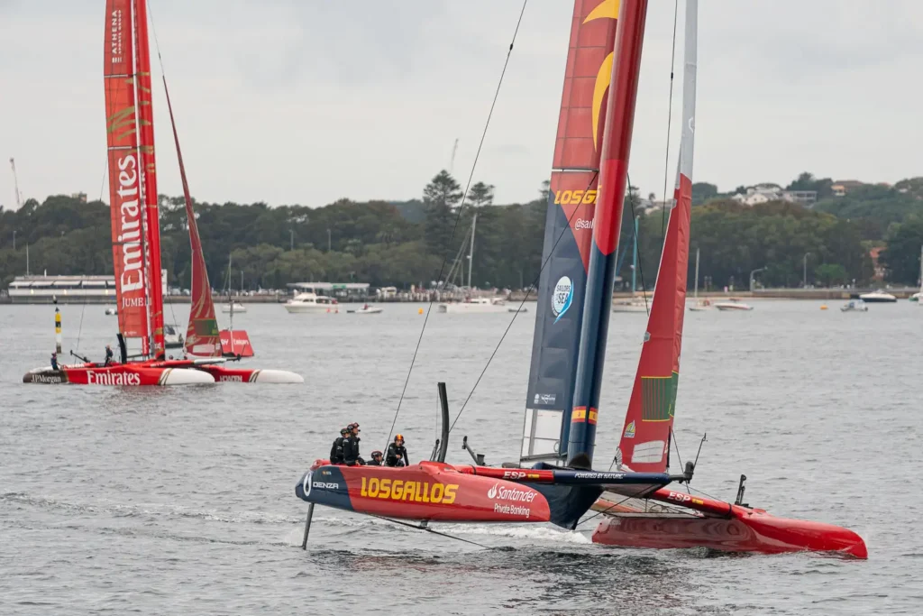 Spain SailGP F50 catamaran foiling with the Emirates Great Britain team in the background on Sydney Harbour