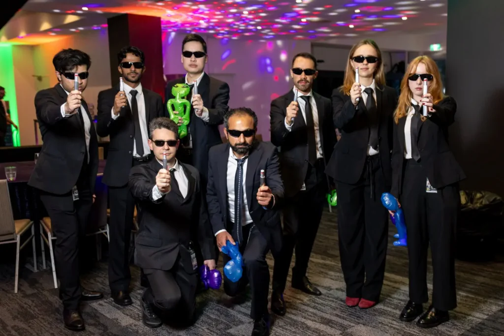 Corporate team in spy-themed costumes during an interactive team building challenge
