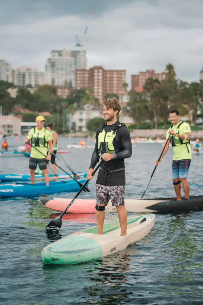 Competitor smiling during the Sydney Harbour paddleboard fundraising event