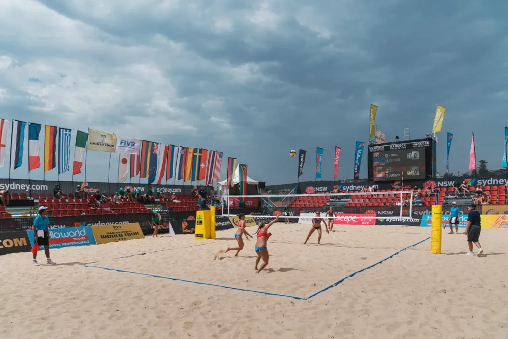 Beach volleyball match under dramatic storm clouds at Manly Beach
