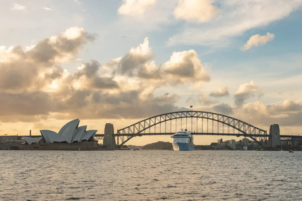 Sunset view of the Sydney Opera House and Harbour Bridge from the water during a yacht cruise