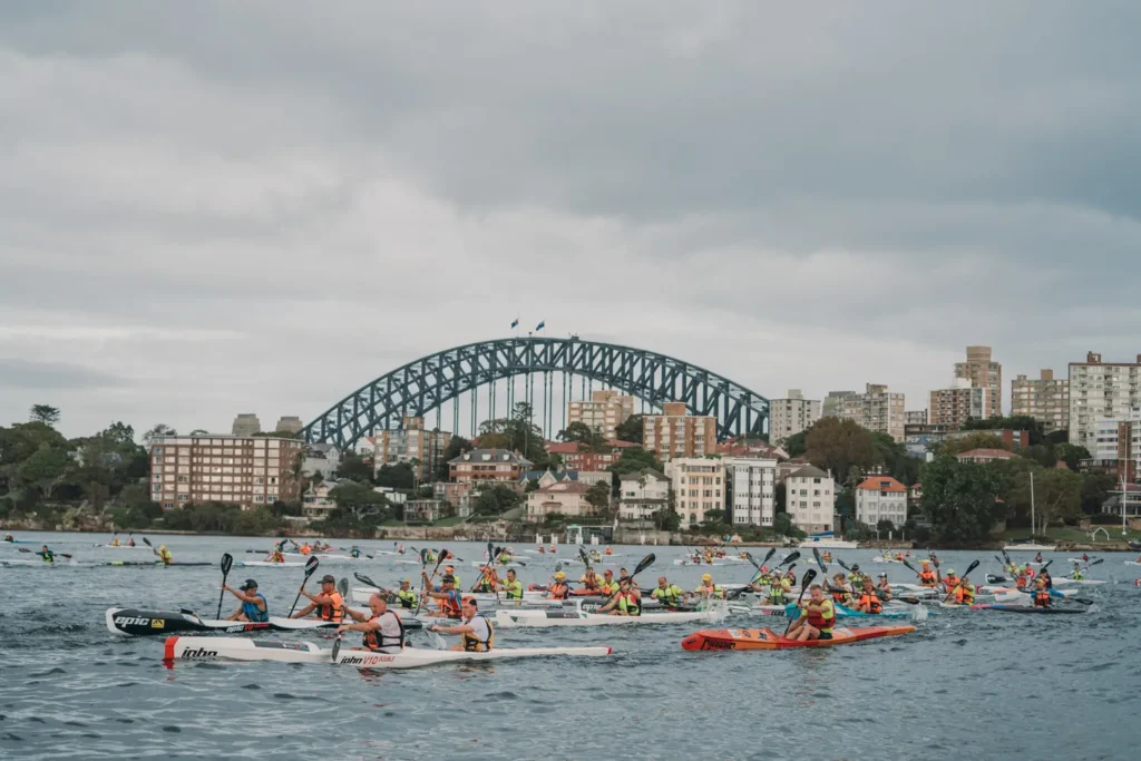 Ocean paddlers racing beneath the Sydney Harbour Bridge during a harbour endurance event